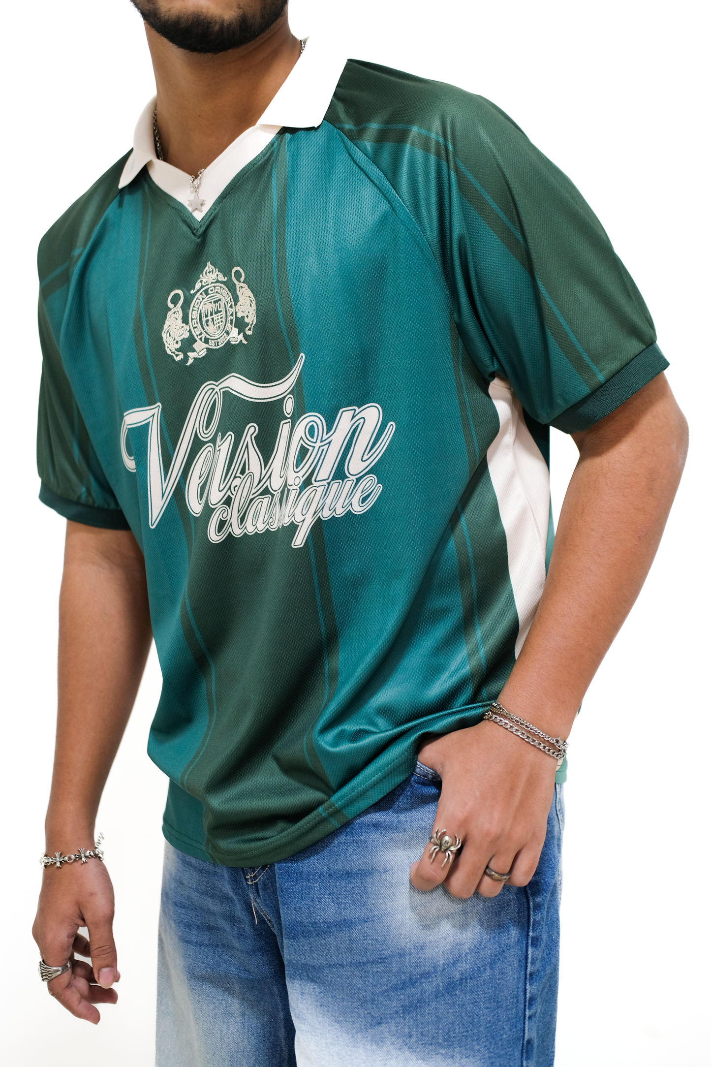 Model wearing Version Originale’s green Version Classique athletic jersey with green vertical panel detailing, beige collar, and beige side panels, styled with washed blue jeans and silver accessories