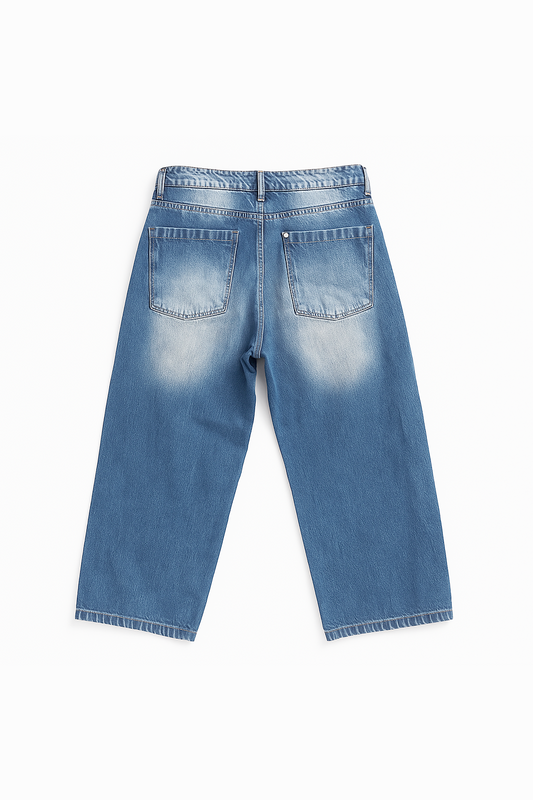 Flat lay of the back view of Version Originale’s denim blue faded jeans, showcasing dual back pockets and subtle back fading for a worn-in look