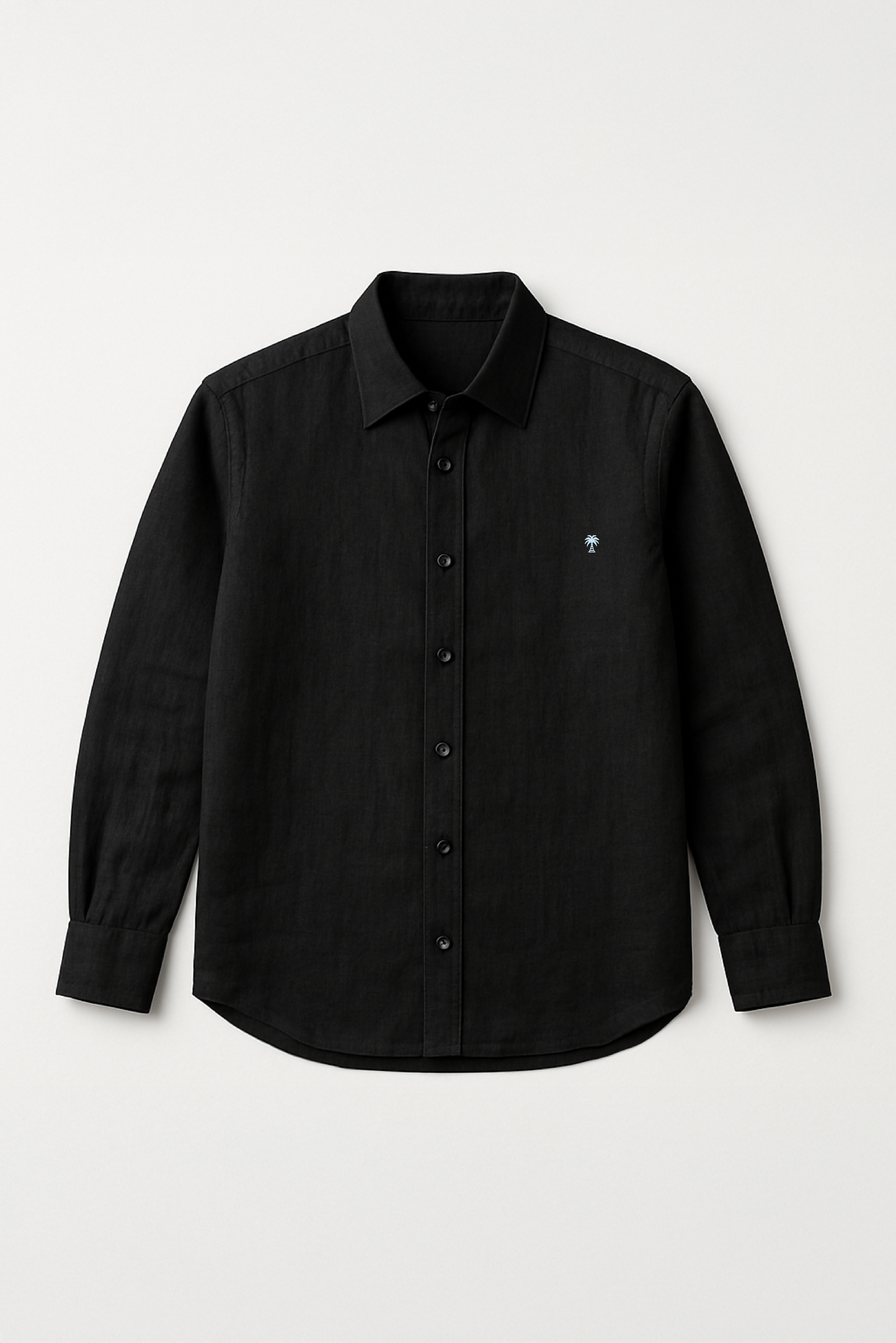 Flat lay of Version Originale's classic black linen shirt featuring a full button-down front and subtle palm tree embroidery on the chest