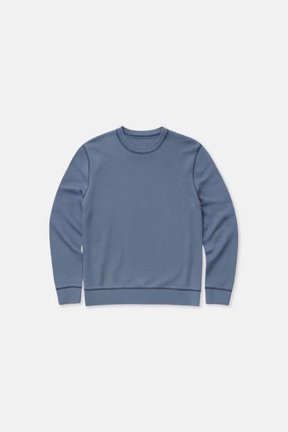 Blue waffle knit sweatshirt on a white background